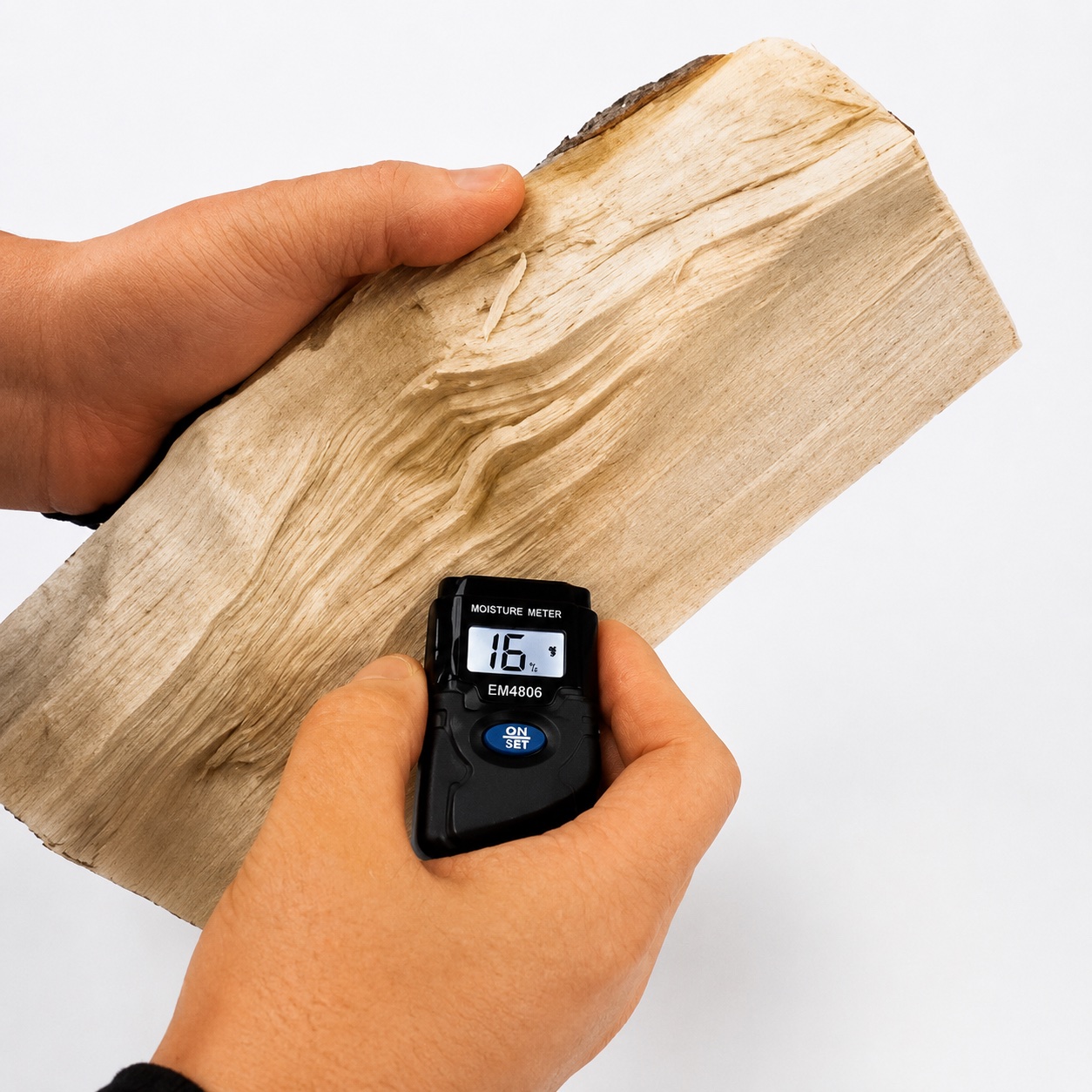 Moisture meter reading 16% on a split log, confirming it is dry and ready to burn